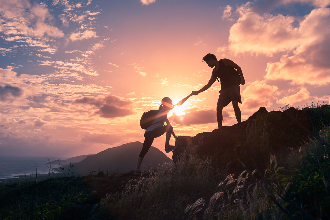 People,Helping,Each,Other,Hike,Up,A,Mountain,At,Sunrise.