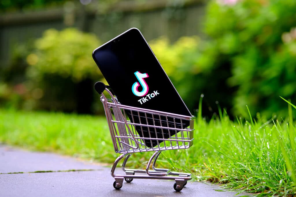 TikTok logo on the smartphone placed in a miniature shopping trolley