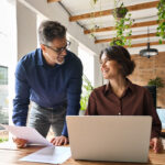 Two happy executive managers working on lapto